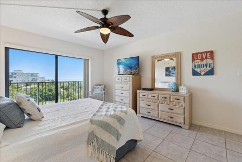 Un dormitorio con una cama y una cómoda y una ventana. en Windrush 509, en Cocoa Beach