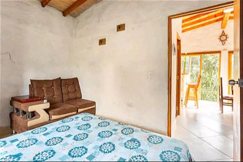 a bedroom with a bed and a couch at Cabaña campestre in Medellín