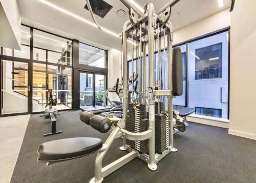 a gym with treadmills and machines in a building at SUPER Location - Modern 2Br Apt-Pool & Gym in Auckland