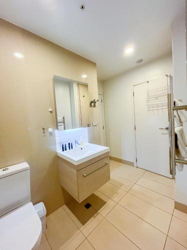 a bathroom with a sink and a toilet at SUPER Location - Modern 2Br Apt-Pool & Gym in Auckland