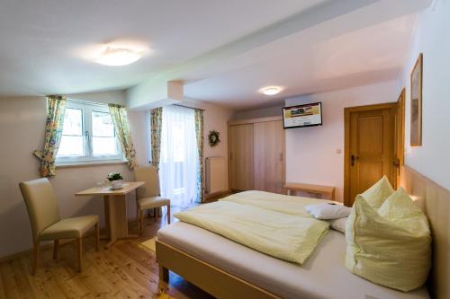 a hotel room with a bed and a small table at Gästehaus Walpurga in Russbach am Pass Gschütt