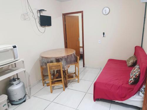 a room with a bed and a table and a microwave at Le case Rosse in Itapoa