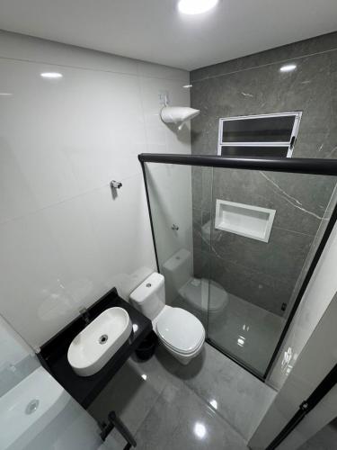a bathroom with a white toilet and a sink at Hotel Vision Guaianases in São Paulo