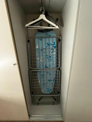 a blue vase in a cage in a closet at Ergli Holiday Apartments in Ērgļi