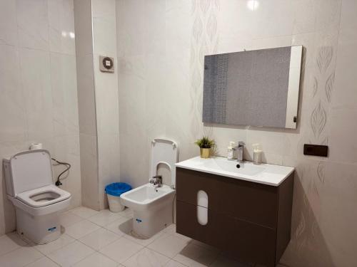 Un baño con inodoro, lavabo y espejo. en Apartment 3 min airport sania ramel tetouan, en Tetuán