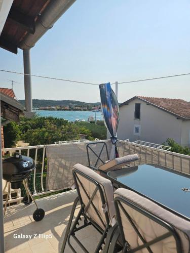a patio with a table and chairs and a grill at Apartman Cvita in Bilice