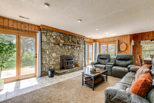a living room with a couch and a stone fireplace at Ski, Hike and Fish Mtn-View Maggie Valley Retreat in Maggie Valley