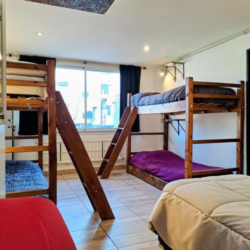 a bedroom with two bunk beds and a window at Nina Hostel in San Carlos de Bariloche