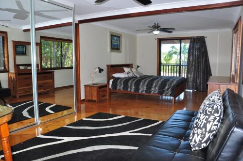a bedroom with a bed and a couch and a mirror at Double Island Dream - Rainbow Beach in Rainbow Beach