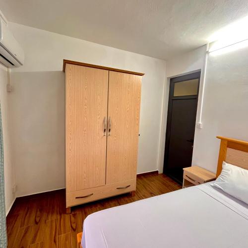 a bedroom with a bed and a wooden cabinet at Casa Soleil in Grand Baie