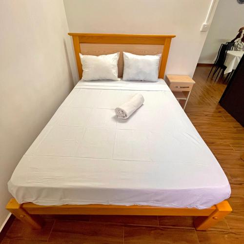 a bed with a white sheets and a towel on it at Casa Soleil in Grand Baie
