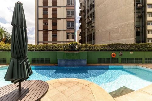 uma grande piscina com um guarda-sol em Kaza Noah The Universe Paulista Bela Vista em São Paulo