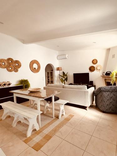 a living room with a table and a couch at Quinta das palmeiras - Aldeia do Pico in Grândola