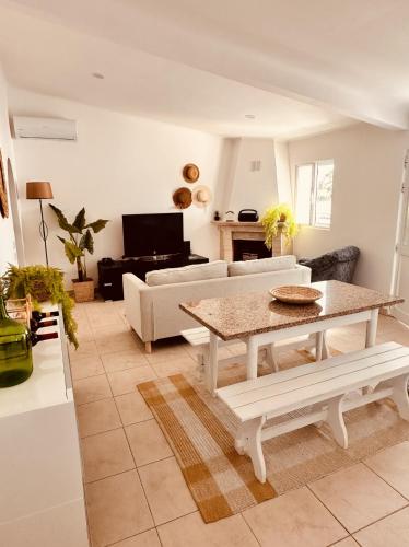 a living room with a table and a couch at Quinta das palmeiras - Aldeia do Pico in Grândola