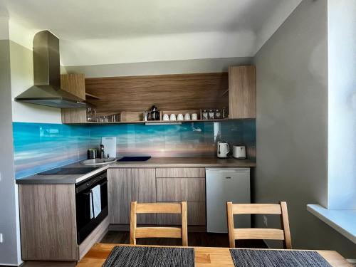 a kitchen with wooden cabinets and a stove top oven at Ergli Holiday Apartments in Ērgļi
