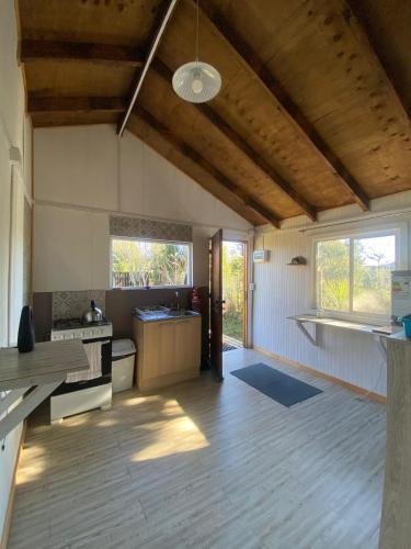 a kitchen with wooden floors and a ceiling with a light at Cabaña Ruta Petrohue in Ensenada