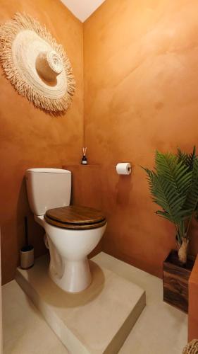 a bathroom with a toilet with a hat on the wall at Escape Zen - Suite and Spa in Chambly