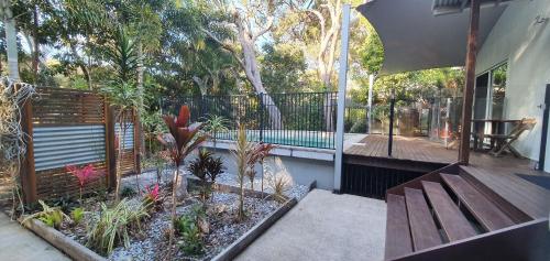 a patio with a bench and a swimming pool at Shelleys - Rainbow Shores in Rainbow Beach