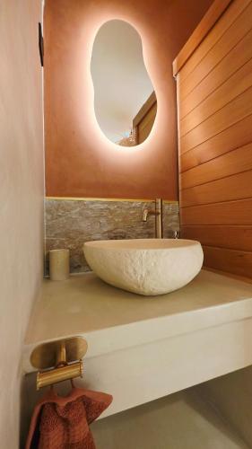 a bathroom with a sink with a round mirror at Escape Zen - Suite and Spa in Chambly