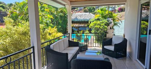 a porch with two chairs and a couch at Kimmy Tahiti House in Punaauia