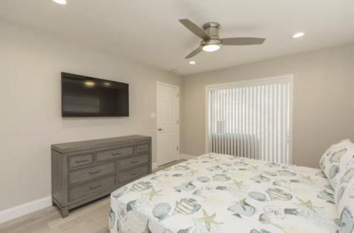 a bedroom with a bed and a flat screen tv at The Seaside Retreat, FREE heated pool in Apollo Beach