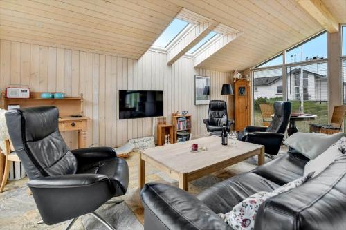 a living room with leather furniture and a tv at HS010-Henne-Hjelmevej-7 in Henne Strand