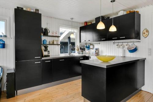 a kitchen with black cabinets and a yellow bowl on the counter at HS010-Henne-Hjelmevej-7 in Henne Strand
