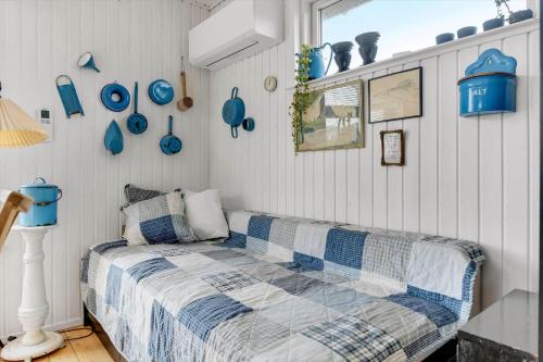 a bedroom with a bed and blue plates on the wall at HS010-Henne-Hjelmevej-7 in Henne Strand
