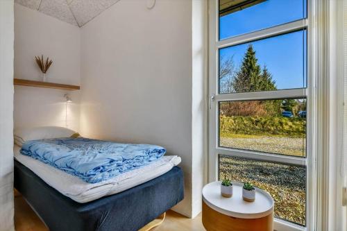 a bedroom with a bed and a window at HS004-Oksbol-Sydskraenten-8 in Øster Vrøgum