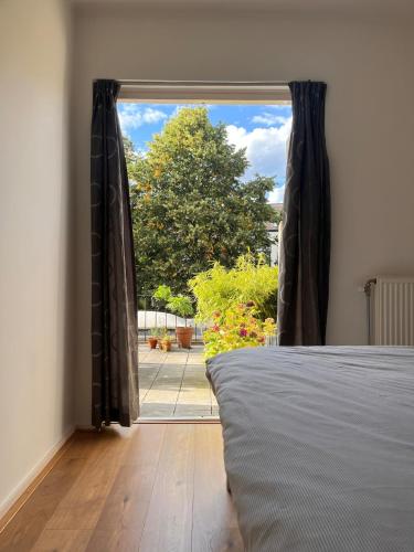 a bedroom with a bed and a large window at Spacious apartment with roof terrace and balcony in Arnhem