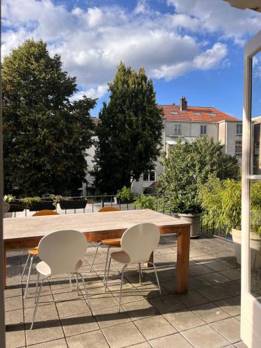 a wooden table and chairs on a patio at Spacious apartment with roof terrace and balcony in Arnhem