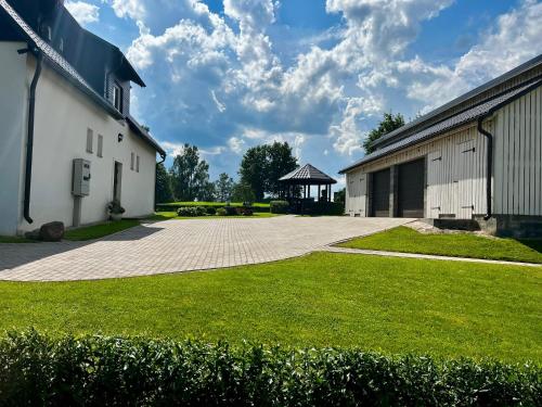 a building with a grass yard next to a building at Ergli Holiday Apartments in Ērgļi