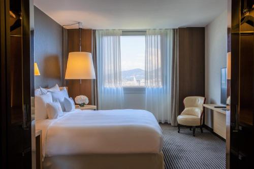 a hotel room with a large bed and a window at InterContinental Genève by IHG in Geneva