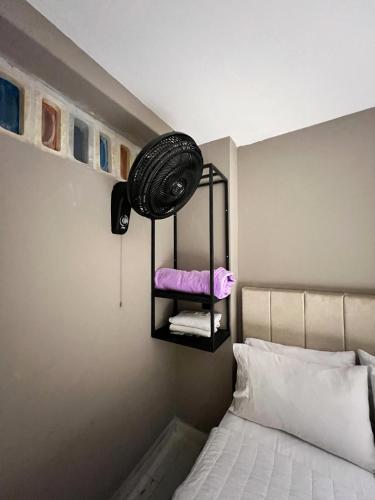 a bedroom with a bed and a fan on the wall at Hotel Natural Medellin in Medellín