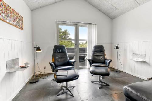 two black leather chairs in a room with a window at HS006-Henne-Musvagevej-18 in Henne Strand