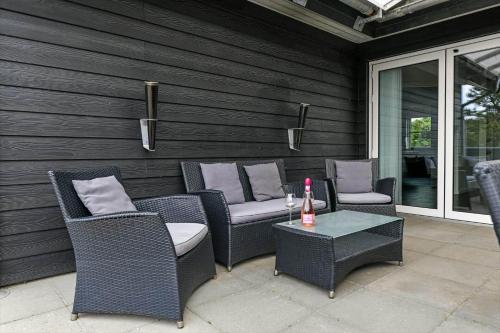 a patio with chairs and a table with a bottle of wine at HS006-Henne-Musvagevej-18 in Henne Strand