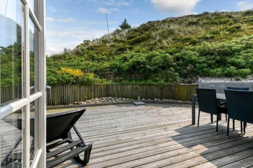 a patio with chairs and a table and a hill at HS008-Henne-Porsevej-10 in Henne Strand