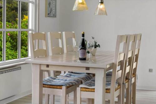 a dining room table with a bottle of wine on it at HS008-Henne-Porsevej-10 in Henne Strand