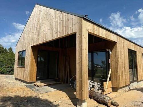 een groot houten gebouw met glazen deuren bij HS001-Henne-Enebaervej-6 in Henne Strand