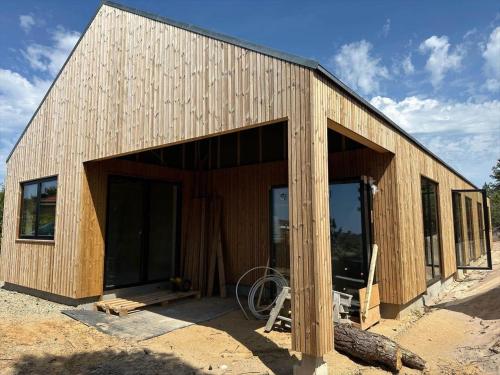 een houten gebouw met een grote deur en ramen bij HS001-Henne-Enebaervej-6 in Henne Strand