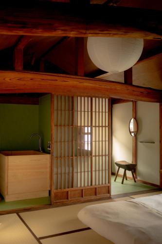 a room with a bed and a table and a window at Akitsu Ryokan in Maibara