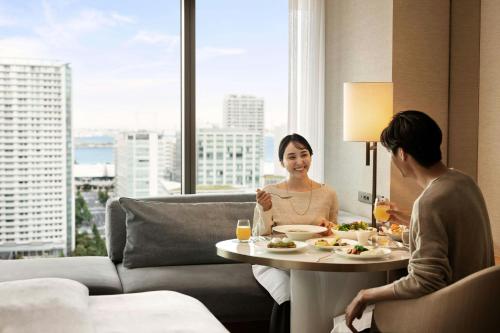 two women sitting at a table in a hotel room eating food at The Westin Yokohama in Yokohama
