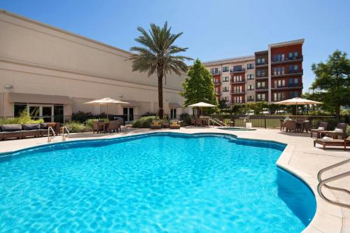 a pool in a hotel with chairs and a building at The Westin Austin at The Domain in Austin