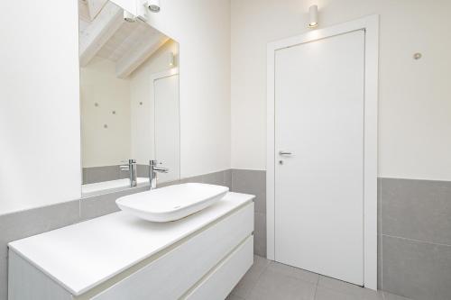 Un baño blanco con lavabo y espejo. en BG Center, en Bérgamo