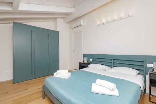 Un dormitorio con una cama azul con toallas. en BG Center, en Bérgamo