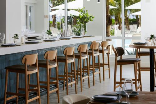 a restaurant with a row of stools at a bar at Fort Lauderdale Marriott Pompano Beach Resort in Pompano Beach