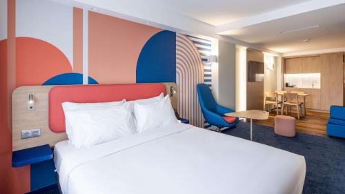 a hotel room with a bed and a dining room at Holiday Inn Express & Suites Lisbon - Príncipe Real by IHG in Lisbon
