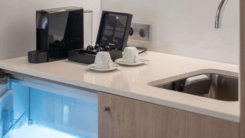 a kitchen counter with a sink and a coffee maker at Holiday Inn Express & Suites Lisbon - Príncipe Real by IHG in Lisbon