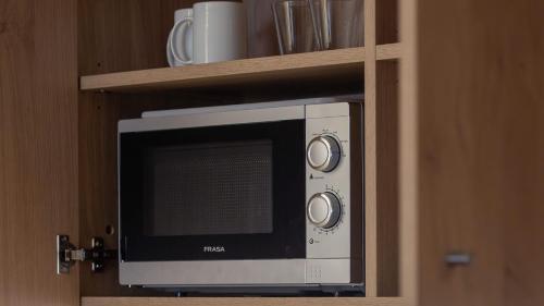 a microwave oven in a cabinet with a shelf at Holiday Inn Express & Suites Lisbon - Príncipe Real by IHG in Lisbon