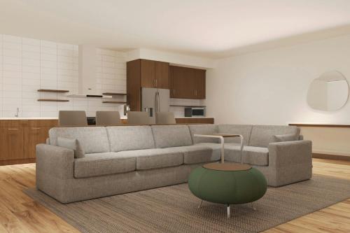 a living room with a couch and a kitchen at Element Opelika Auburn in Opelika